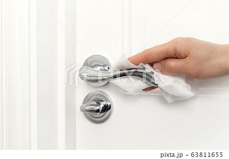 A person cleaning door handle to prevent the spread of germs, bacteria and coronavirus A person cleaning door handle to prevent the spread of germs, bacteria and coronavirus 63811655