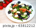 Greek salad with tomatoes, cucumbers and feta cheese with olives on the table 63812212