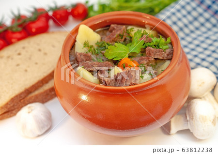 Roast in a pot with beef meat and potatoes on the table Roast in a pot with beef meat and potatoes on the table 63812238
