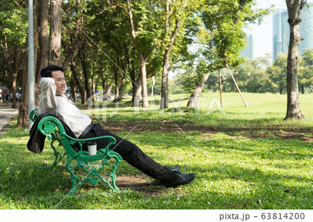 Businessman sitting and relaxing on green Chair in Businessman sitting and relaxing on green Chair in 63814200