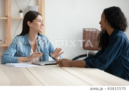 Diverse female colleagues talk at office meeting 63815570