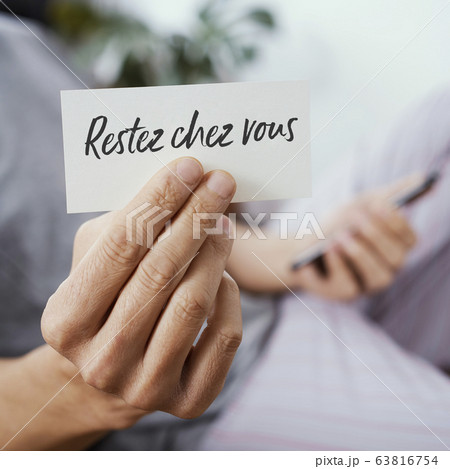 man showing the message stay at home in french man showing the message stay at home in french 63816754