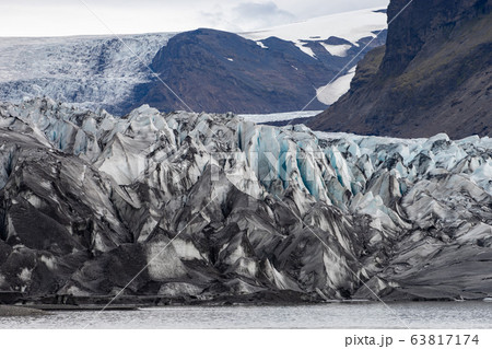 Glacier with ash in the ice with melted water and Icelandic landscape  63817174
