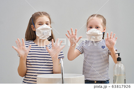 Girls are wearing face masks and washing their Girls are wearing face masks and washing their 63817926