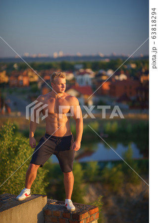 Muscular man on top of the roof during sunset. healthy lifestyle, confident Muscular man on top of the roof during sunset. healthy lifestyle, confident 63818294