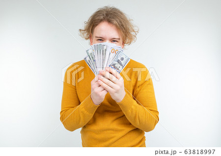 happy blond guy won money on a white background 63818997