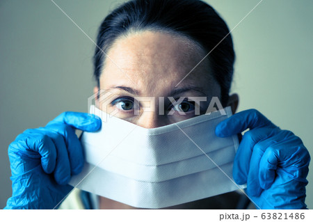 portrait of female doctor wearing protective mask and looking at camera posing against white background portrait of female doctor wearing protective mask and looking at camera posing against white background 63821486