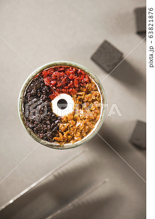 Multicolored tobacco in a filled bowl of hookah. 63821876