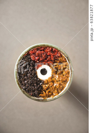 Multicolored tobacco in a filled bowl of hookah. 63821877