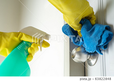Cleaning door knob with alcohol spray for Covid-19 Coronavirus prevention Cleaning door knob with alcohol spray for Covid-19 Coronavirus prevention 63822848