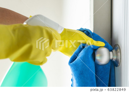 Cleaning door knob with alcohol spray for Covid-19 Coronavirus prevention Cleaning door knob with alcohol spray for Covid-19 Coronavirus prevention 63822849