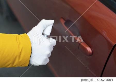 Female hands close up disinfect a car door handle 63823604