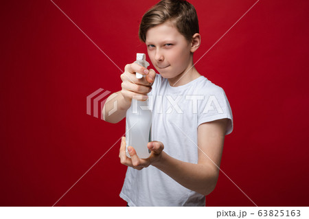 Portrait of fearless teenage male holding spray Portrait of fearless teenage male holding spray 63825163