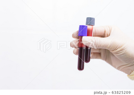 Covid-19, pandemic and coronavirus concept - hand holding blood in tests tubes close up, white background with copy space. Covid-19, pandemic and coronavirus concept - hand holding blood in tests tubes close up, white background with copy space. 63825209