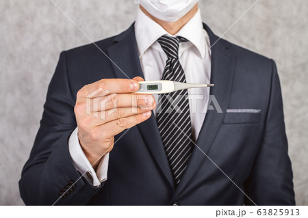 A man in a suit and tie holds in his hands an A man in a suit and tie holds in his hands an 63825913