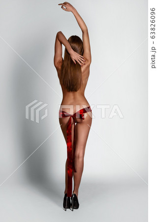 Sexy slim lady with red ribbon on her butt 63826096