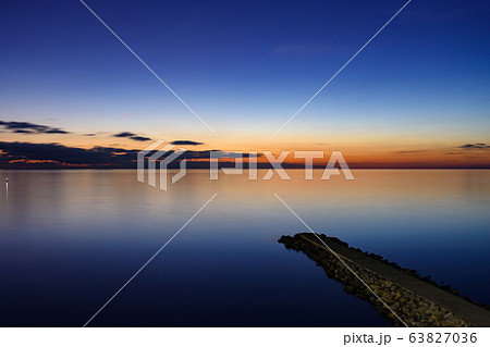 Seascape after sunset, breakwater goes from the Seascape after sunset, breakwater goes from the 63827036