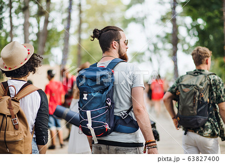 Rear view of group of young friends at summer festival, walking. 63827400