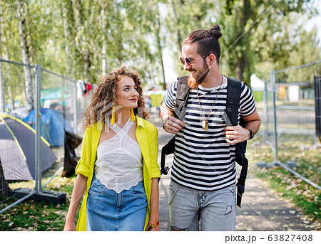 Young couple at summer festival or camping holiday, walking. 63827408