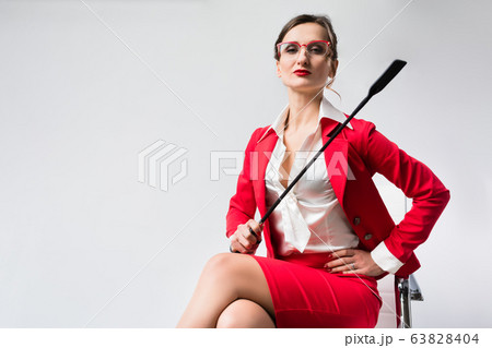 Arrogant businesswoman with a whip in her chair 63828404