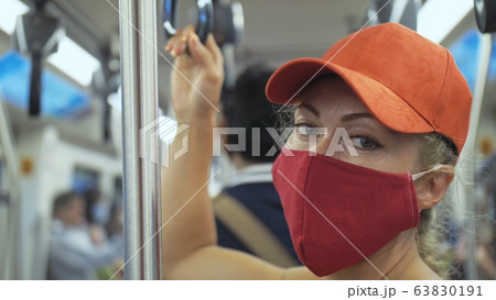 Woman travel caucasian ride at overground train airtrain with wearing protective medical mask. Girl tourist at airtrain with respirator. People mask. 63830191