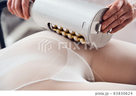 Masseur makes apparatus anti-cellulite massage in the cosmetology clinic Masseur makes apparatus anti-cellulite massage in the cosmetology clinic 63830624