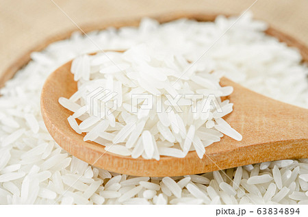 raw rice in wooden spoon. raw rice in wooden spoon. 63834894