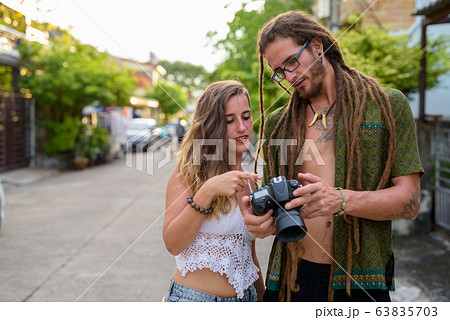 Young Hispanic tourist couple together in the streets outdoors Young Hispanic tourist couple together in the streets outdoors 63835703