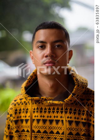 Young multi-ethnic Asian man in the streets outdoors Young multi-ethnic Asian man in the streets outdoors 63835897