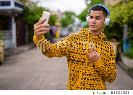 Young multi-ethnic Asian man in the streets outdoors 63835923