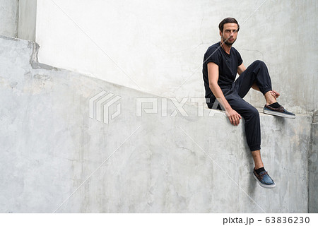 Handsome man against concrete wall in the streets outdoors 63836230