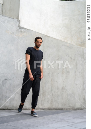 Handsome man against concrete wall in the streets outdoors 63836231