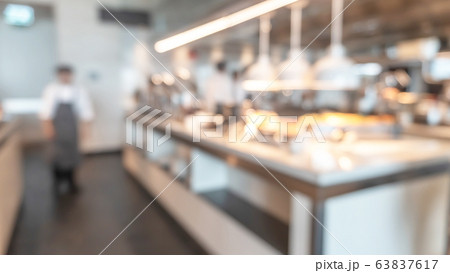 Buffet at hotel restaurant interior blur background with blurry open kitchen counter bar of food catering service business with chef staff cooking for breakfast, lunch or dinner meal 63837617