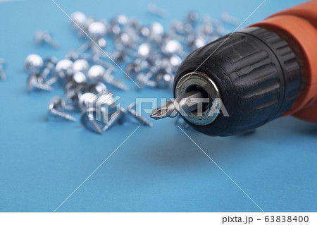 screwdriver and screws on blue paper. Blurred 63838400