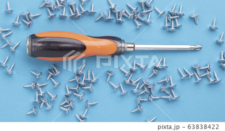 Orange screwdriver and many screws on metal table, Orange screwdriver and many screws on metal table, 63838422