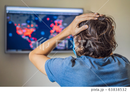 Young man checks coronavirus sars-cov-2 covid-19 global cases situation online. Coronavirus outbreak Young man checks coronavirus sars-cov-2 covid-19 global cases situation online. Coronavirus outbreak 63838532