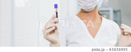 Covid-19, coronavirus, pandemic and viruses concept - woman holding blood in tests tubes close up, background with copy space. Covid-19, coronavirus, pandemic and viruses concept - woman holding blood in tests tubes close up, background with copy space. 63838995