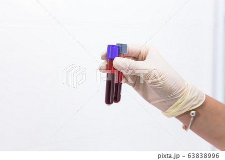 Covid-19, pandemic and coronavirus concept - hand holding blood in tests tubes close up, white background with copy space. Covid-19, pandemic and coronavirus concept - hand holding blood in tests tubes close up, white background with copy space. 63838996