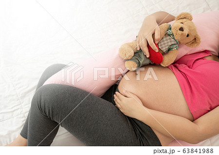 Happy pregnant woman sleeping on bed in bedroom. Happy pregnant woman sleeping on bed in bedroom. 63841988