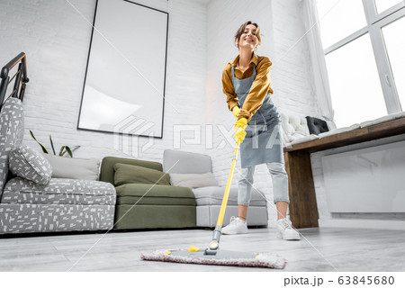 Housewife portrait with a mop indoors Housewife portrait with a mop indoors 63845680