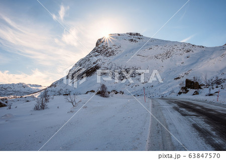 Sunshine on snowy mountain with rural road on 63847570