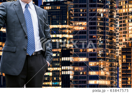 Smart businessman standing on office building Smart businessman standing on office building 63847575
