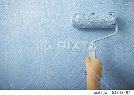 Idea for home interior. Girl paints wall in blue 63848494