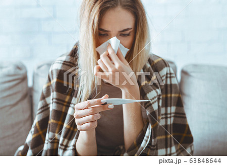 Girl looks at thermometer and wipes over napkin 63848644