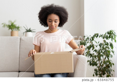 Millennial female open postal package buy on internet Millennial female open postal package buy on internet 63848755