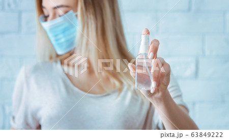 Girl turns away and sprinkles with antiseptic 63849222