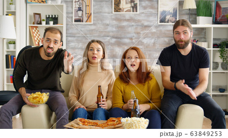 Girl scared by a bug while watching movie with her friends 63849253