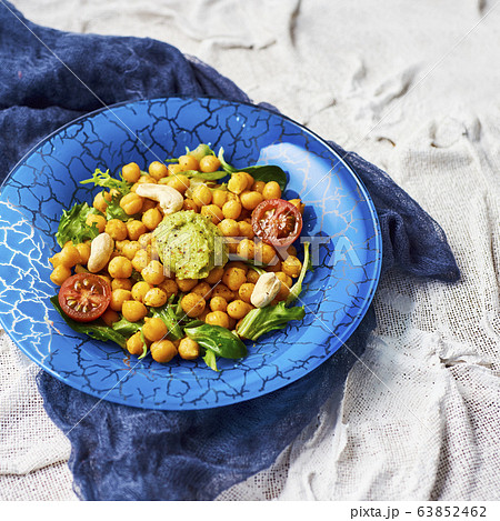chickpea salad in a blue glass plate 63852462