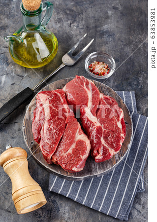 Raw beef steak on dark gray background 63853981