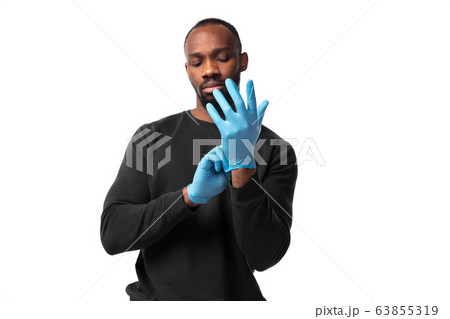 How coronavirus changed our lives. Young man holding thermometer, taking temperature on white background How coronavirus changed our lives. Young man holding thermometer, taking temperature on white background 63855319